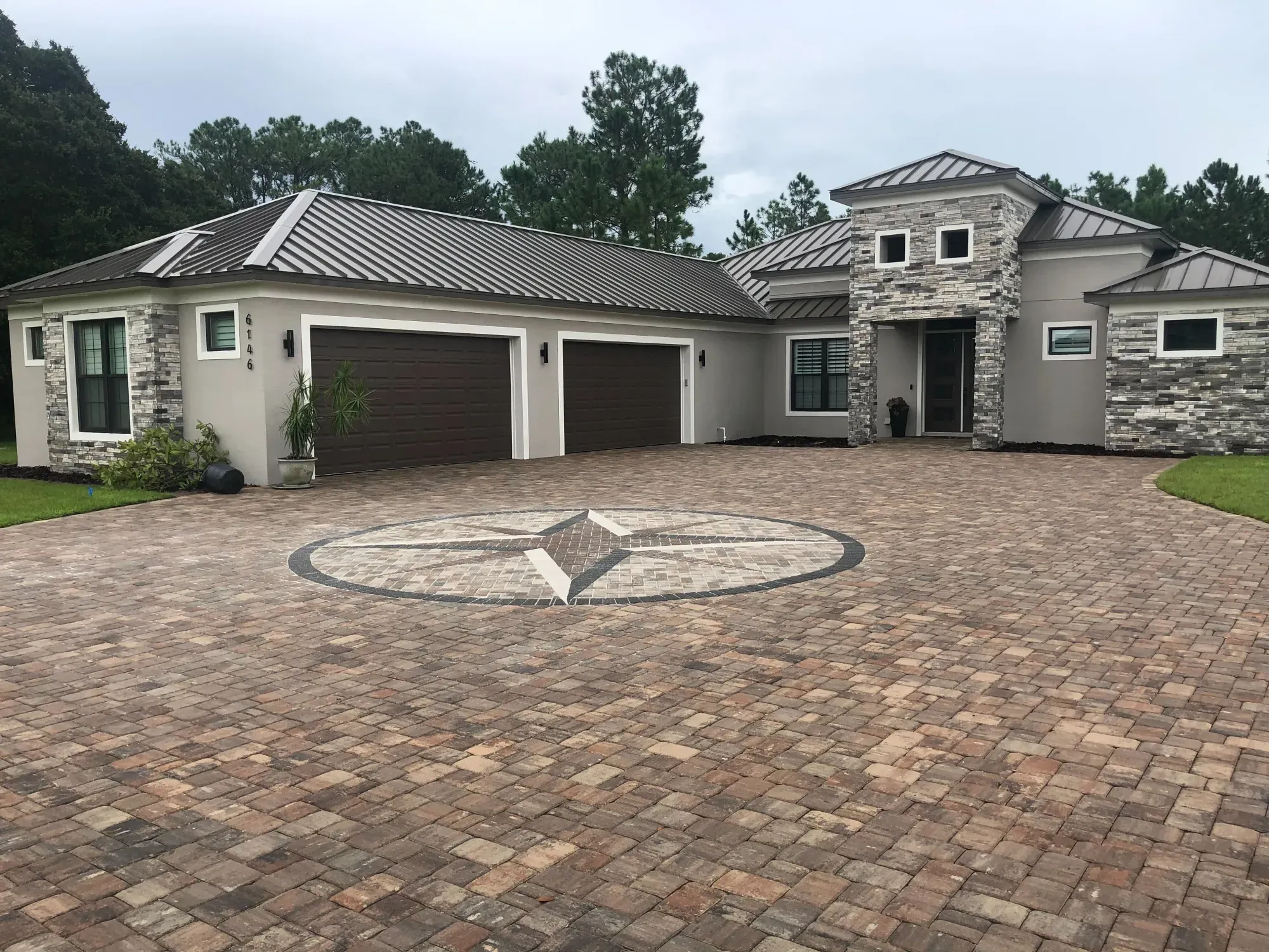 Custom paver driveway with inlaid compass medallion