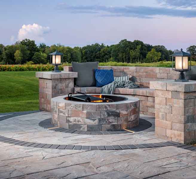 Stone fire pit with built-in seating at dusk