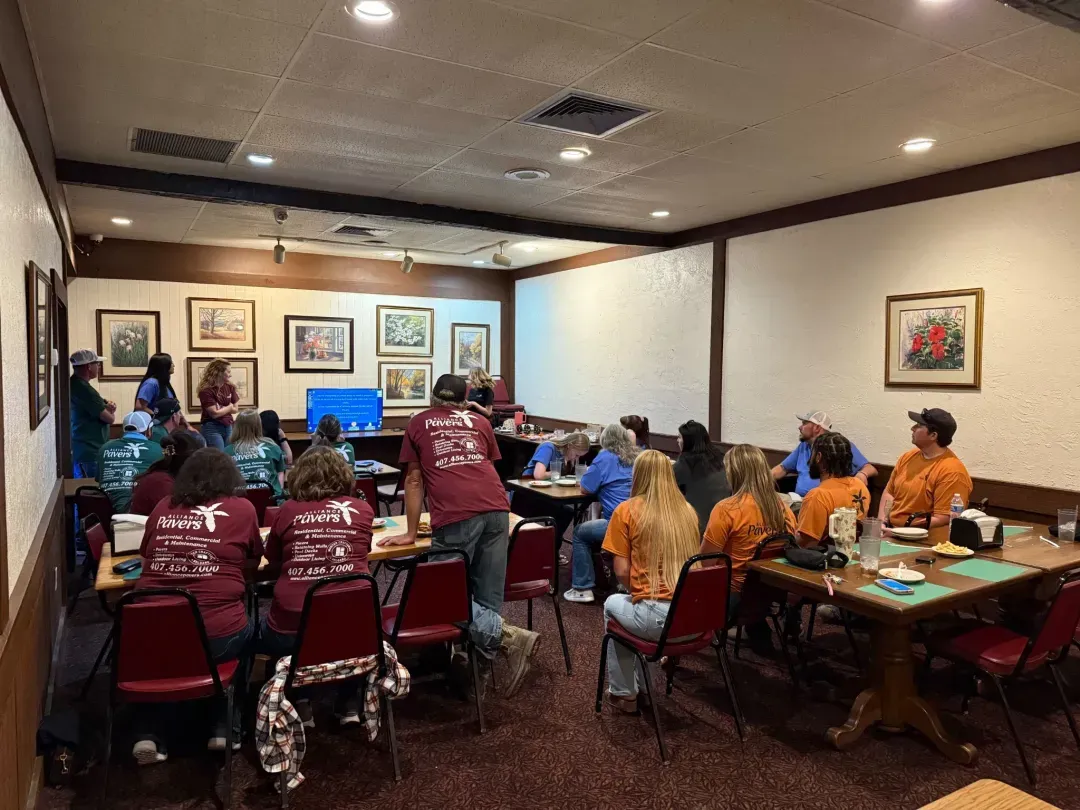 Alliance Pavers team members seated together during a company meeting.