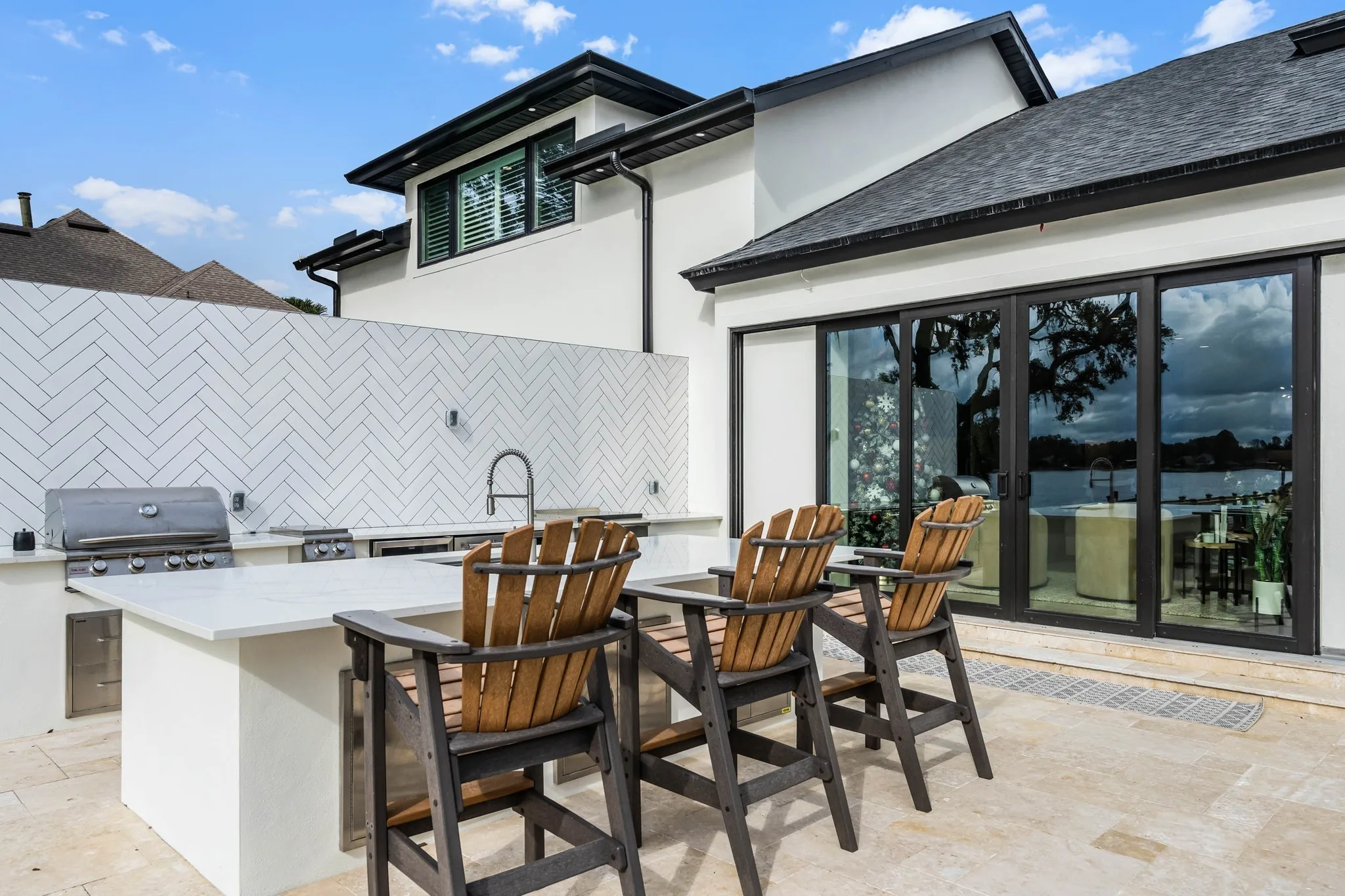 Custom outdoor kitchen and barbecue island with bar seating built by Alliance Pavers