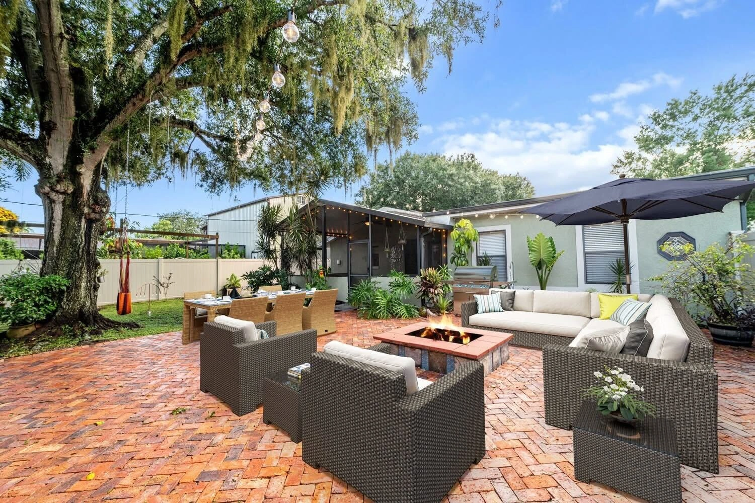 Covered outdoor lounge and paver patio with fire feature