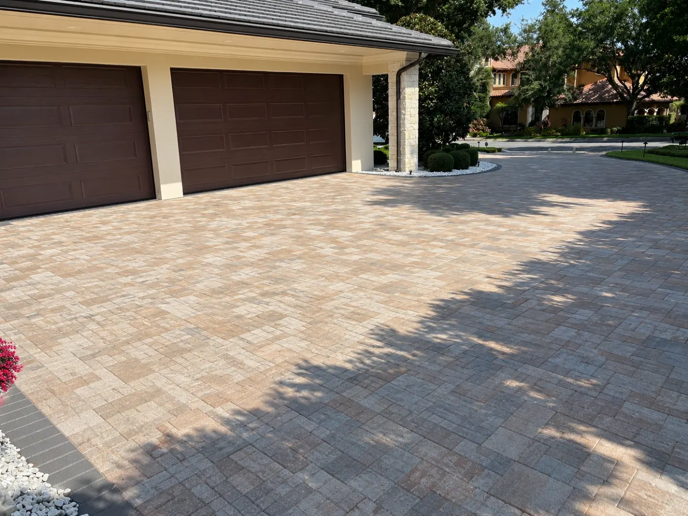 Paver garage court with a dark paver border in front of a three-car garage